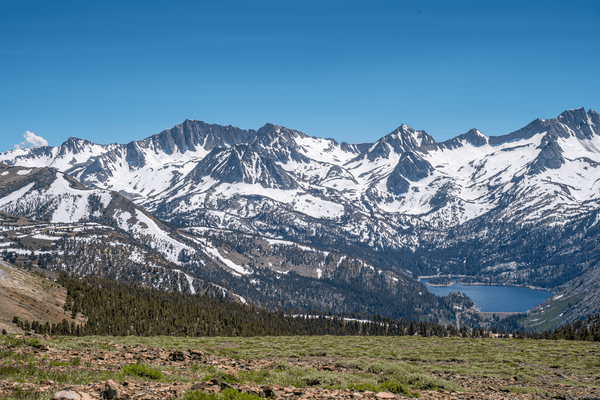 Snow-covered Sierra Nevada peaks and a deep blue alpine lake seen from a high ridge during the Coyote Flats overland trip, September 4–7, 2026.