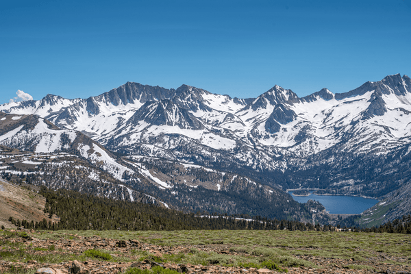 Snow-covered Sierra Nevada peaks and a deep blue alpine lake seen from a high ridge during the Coyote Flats overland trip, September 4–7, 2026.
