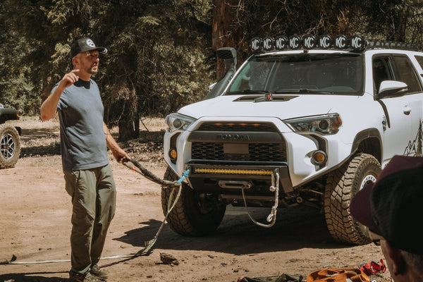 Instructor demonstrating proper winch setup and kinetic recovery rope connection in front of a modified Toyota 4Runner during the Weekend Offroad Driving Workshop.