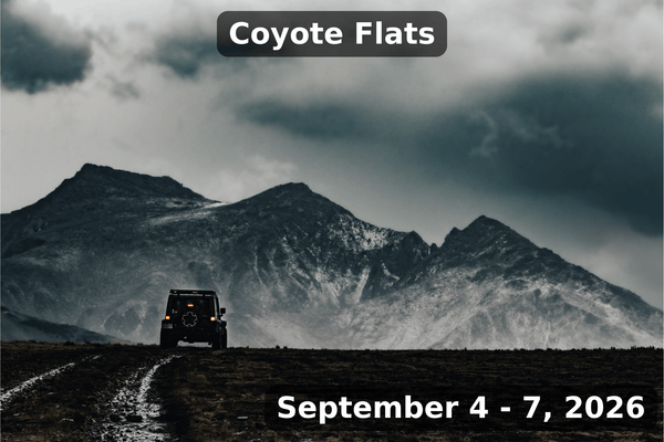 A lone off-road vehicle drives along a muddy trail toward dramatic dark mountains under stormy skies. The image includes labeled text at the top reading “Coyote Flats” and at the bottom “September 4 - 7, 2026.”