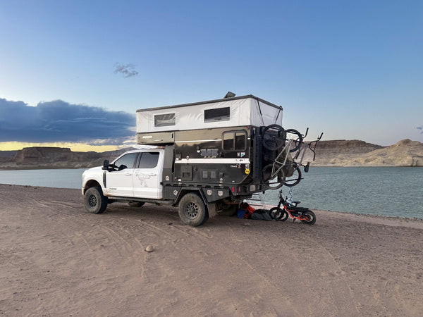 Overlanding truck with rooftop camper parked beside a lake during the Lake and Canyon Relaxation 2026 trip.