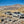 Three off-road vehicles driving in a dusty convoy through rocky desert terrain with mountains in the background during the Weekend Offroad Death Valley trip.